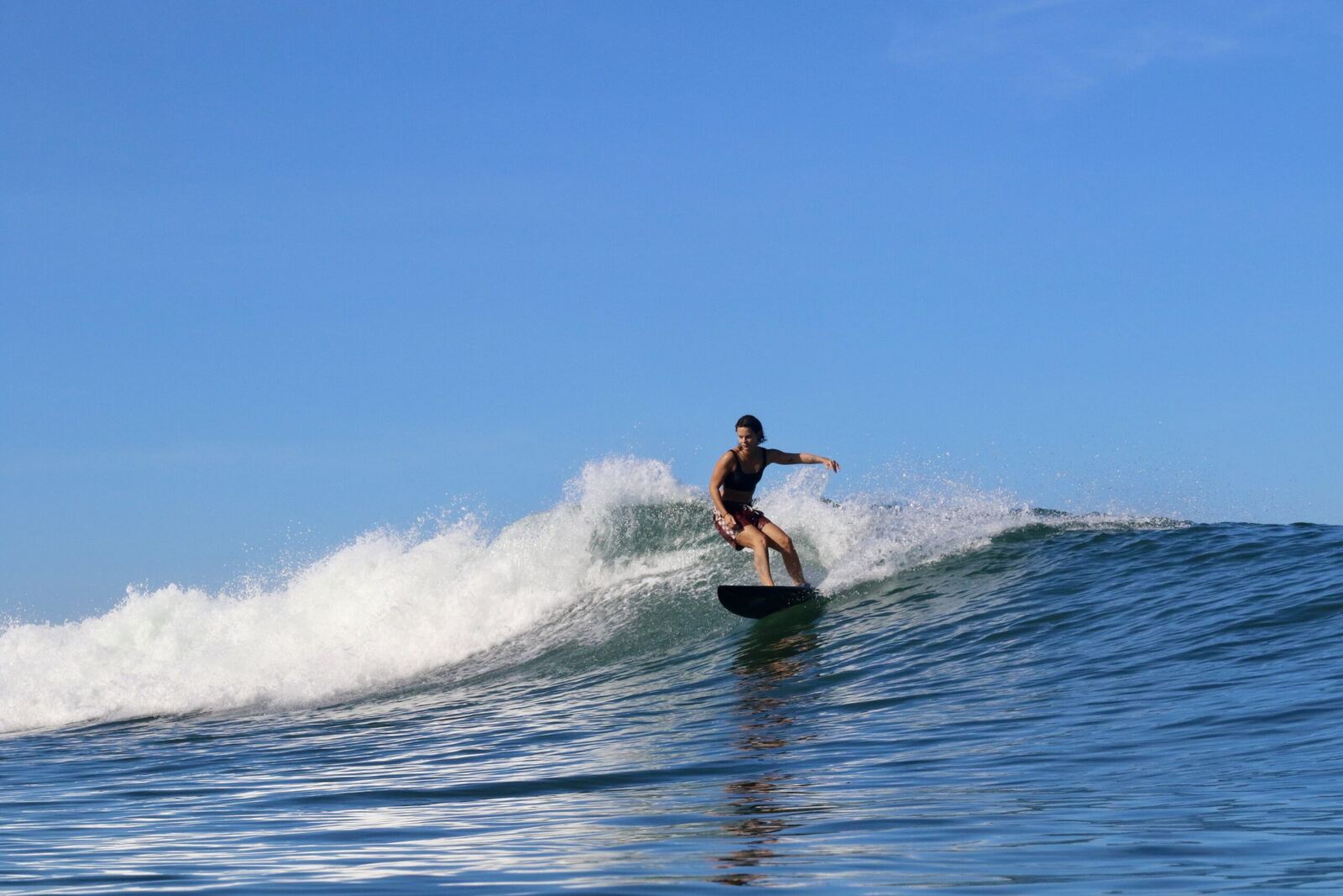 Surfer riding a clean open wave on a sunny day