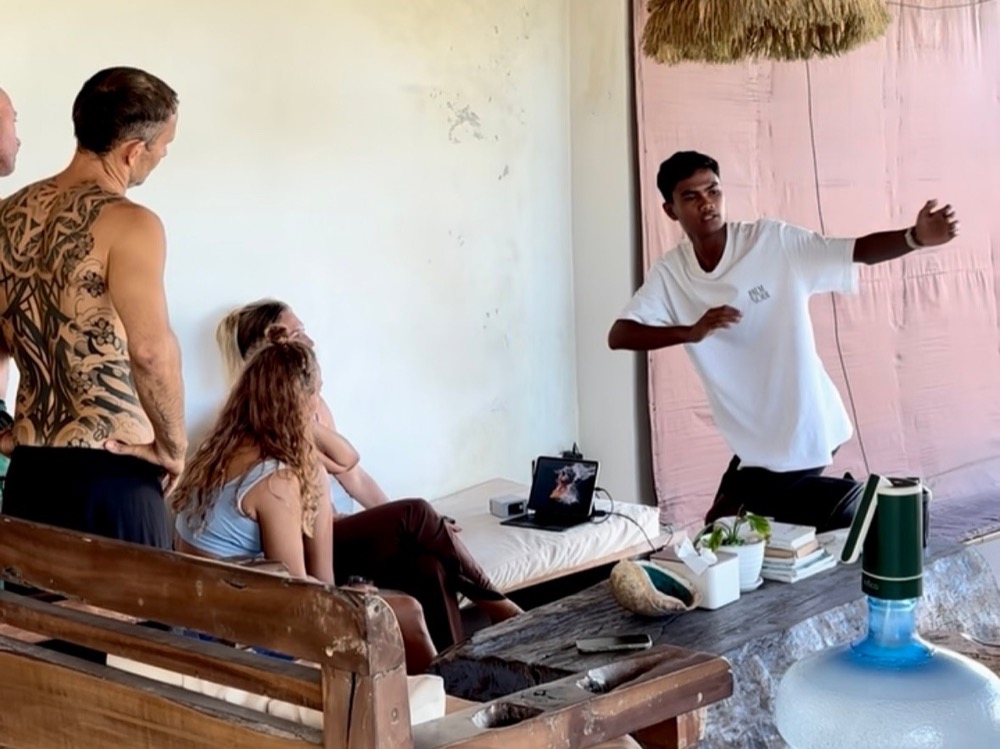 A group watching a video review session at DISINI Surf House