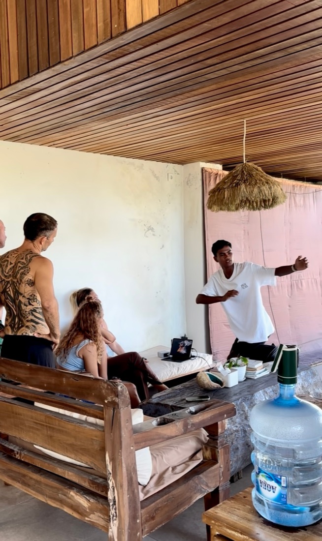 Guests and coach watching the morning's surf footage together at DISINI